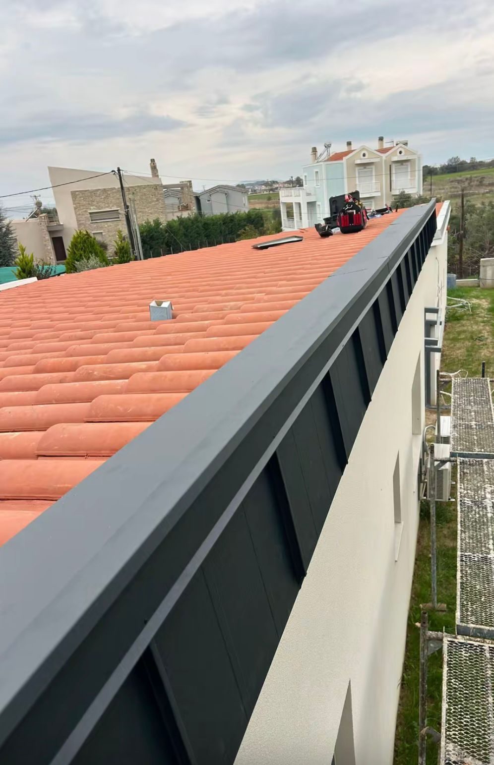 Întreținerea acoperișului înainte de iarnă: lista de verificare în 10 puncte — Sistem pluvial pentru acoperiș. Jgheaburi și burlane montate pentru evacuarea eficientă a apei.